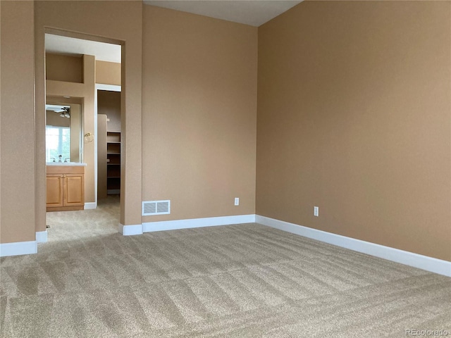 spare room featuring light carpet