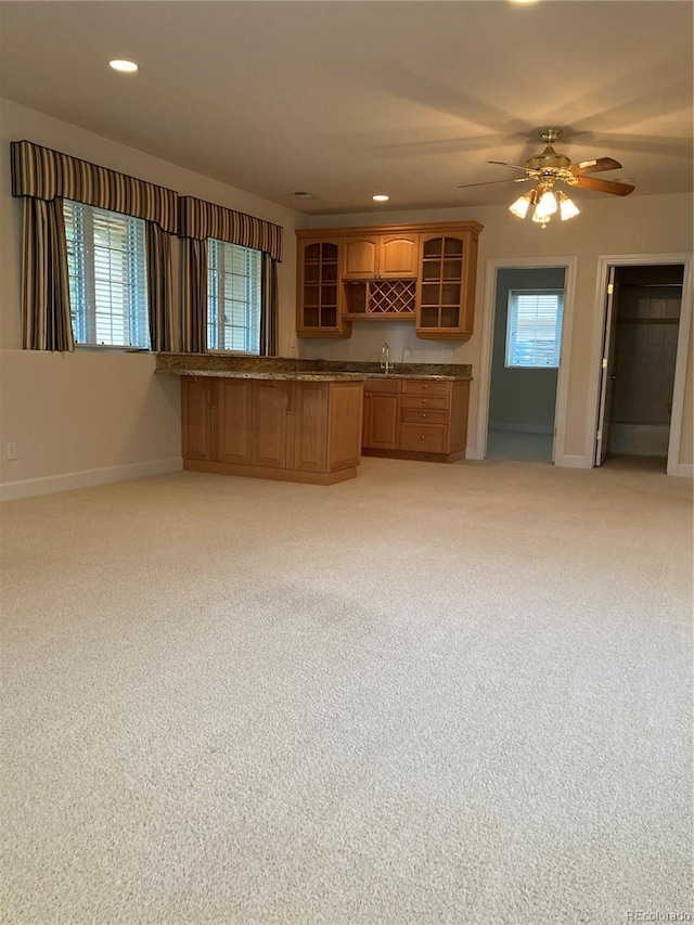 kitchen featuring ceiling fan, light carpet, and sink