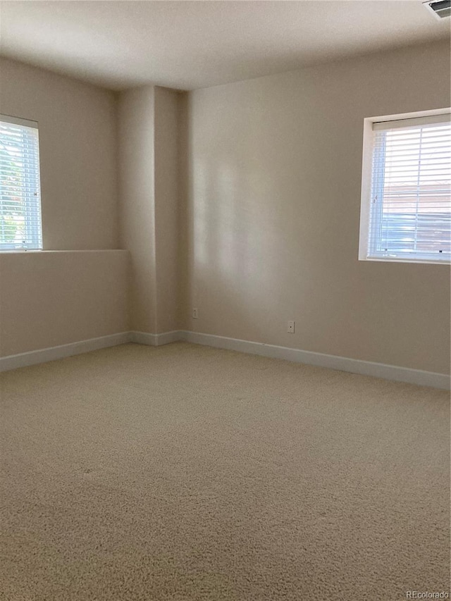 carpeted spare room featuring a wealth of natural light