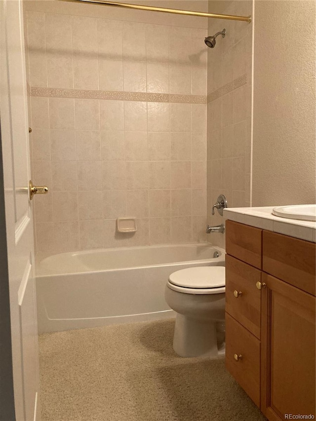 full bathroom featuring tiled shower / bath combo, vanity, and toilet