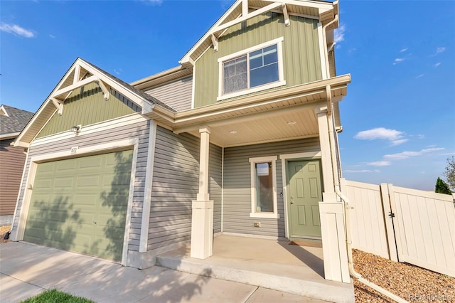 craftsman house featuring a gate, fence, board and batten siding, an attached garage, and a porch