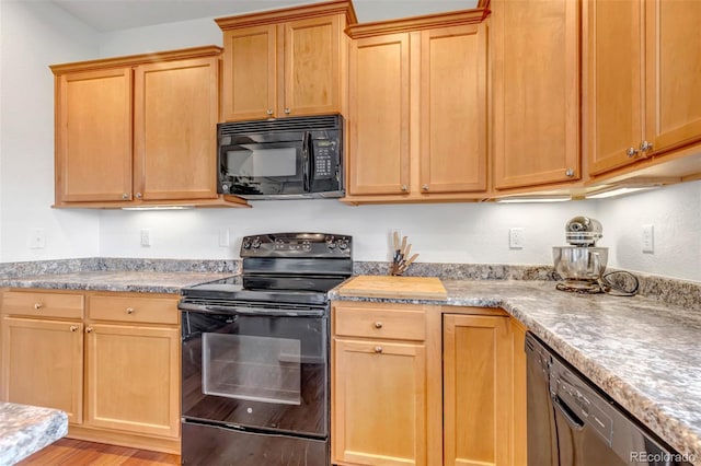 kitchen with light countertops, light wood-style floors, and black appliances