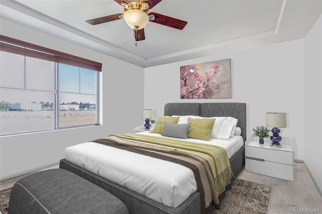 carpeted bedroom featuring a ceiling fan, baseboards, and a raised ceiling