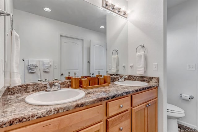full bathroom featuring double vanity, toilet, and a sink