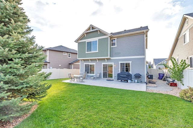 back of house with a lawn, a patio, a fenced backyard, and board and batten siding