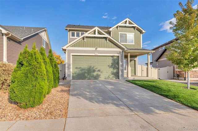craftsman-style house with a gate, concrete driveway, a front lawn, board and batten siding, and fence