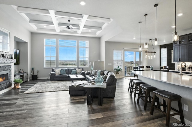 9538 Bear River St, Littleton, CO 80125 - living area featuring a ceiling fan, dark wood finished floors, a fireplace, beam ceiling, and coffered ceiling