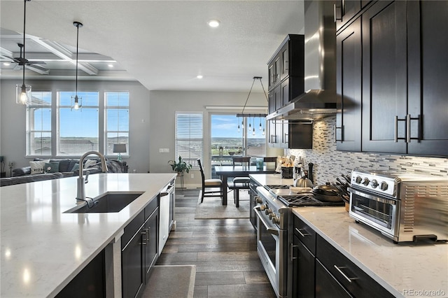 9538 Bear River St, Littleton, CO 80125 - kitchen featuring stainless steel stove, wall chimney exhaust hood, dark cabinetry, recessed lighting, and ceiling fan