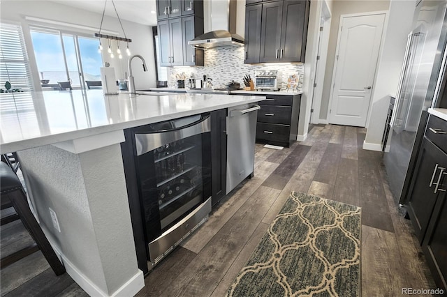 9538 Bear River St, Littleton, CO 80125 - kitchen with wall chimney range hood, beverage cooler, dark wood-style floors, backsplash, and light countertops