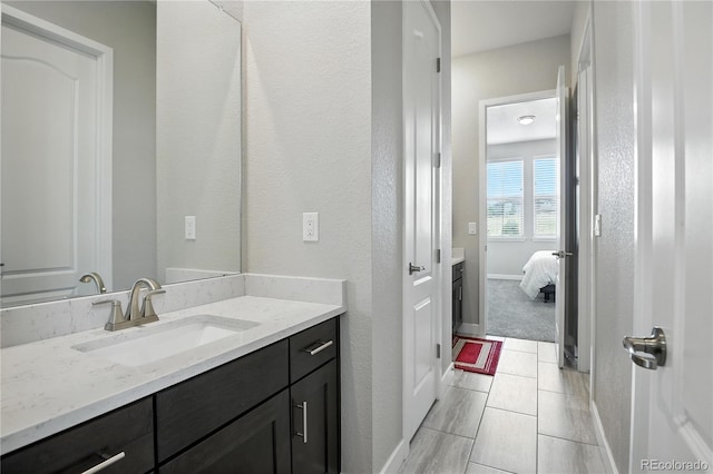 9538 Bear River St, Littleton, CO 80125 - ensuite bathroom with vanity, a textured wall, and tile patterned floors