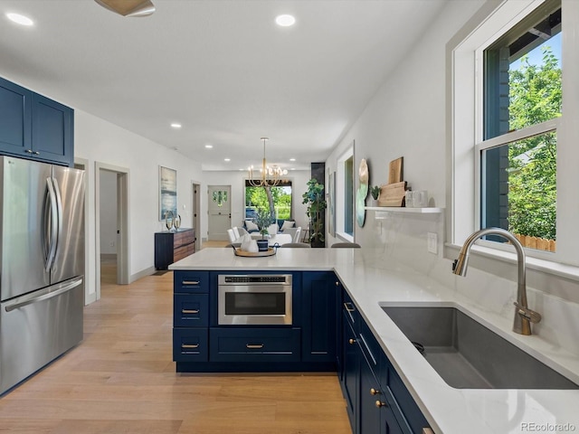 883 S Downing St, Denver, CO 80209 - kitchen with freestanding refrigerator, blue cabinets, a peninsula, recessed lighting, and a chandelier