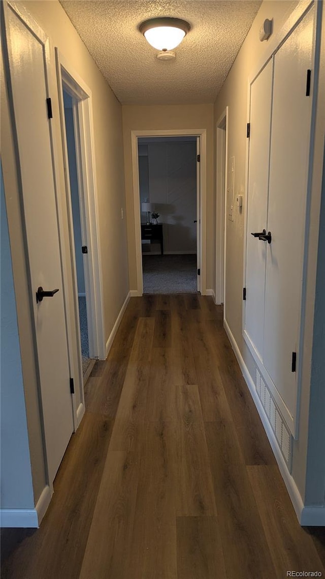 12506 E Cornell Ave Unit 201, Aurora, CO 80014 - hallway featuring a textured ceiling, wood finished floors, and baseboards