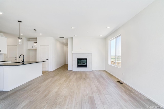 unfurnished living room featuring light hardwood / wood-style flooring and sink