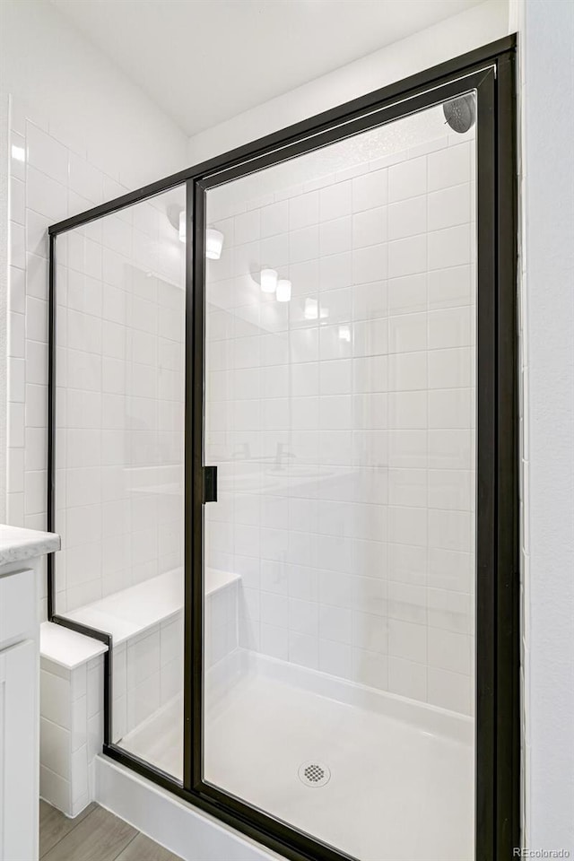 bathroom with a shower with door, vanity, and hardwood / wood-style flooring