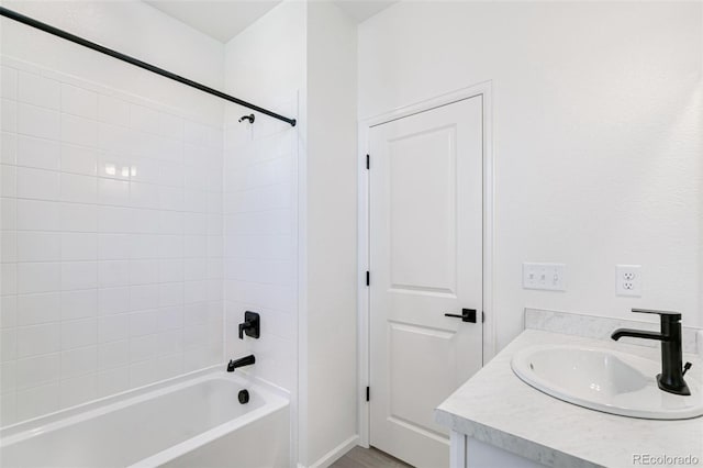 bathroom featuring vanity and tiled shower / bath