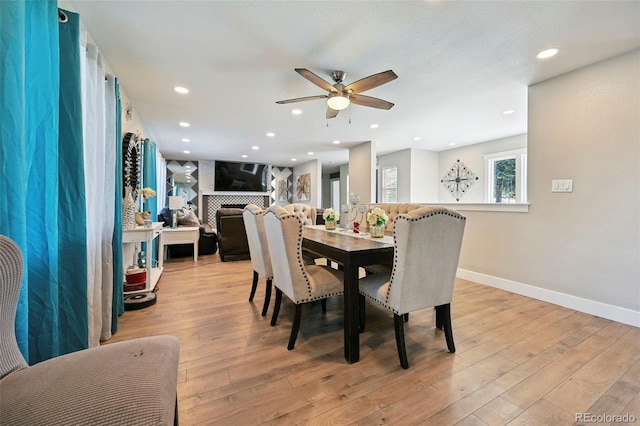 3340 Afternoon Cir, Colorado Springs, CO 80910 - dining room with a ceiling fan, light wood-style floors, a fireplace, and recessed lighting