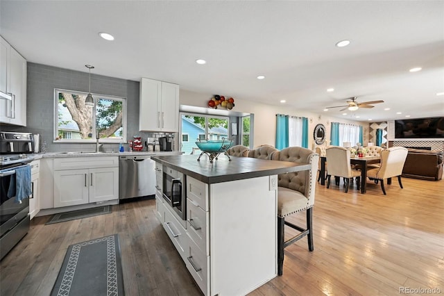 3340 Afternoon Cir, Colorado Springs, CO 80910 - kitchen featuring stainless steel appliances, a breakfast bar area, open floor plan, a ceiling fan, and white cabinets