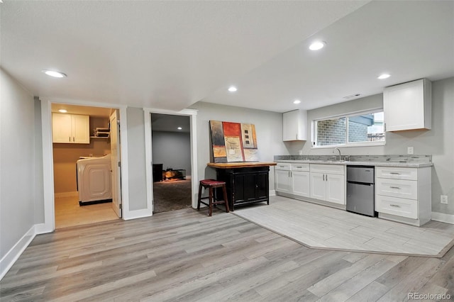 3340 Afternoon Cir, Colorado Springs, CO 80910 - kitchen with fridge, washer / clothes dryer, light wood finished floors, white cabinetry, and recessed lighting