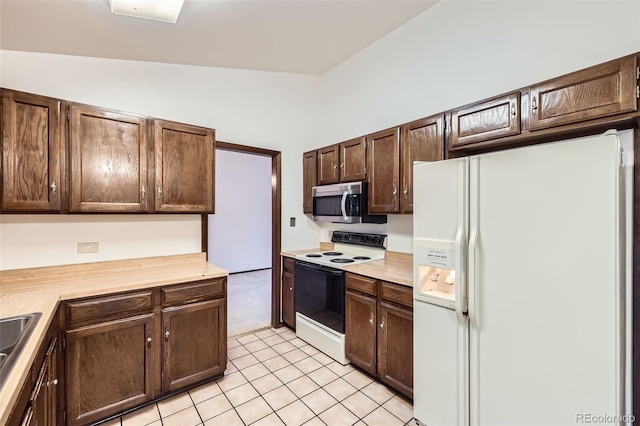 2556 S Eagle Cir, Aurora, CO 80014 - kitchen with white refrigerator with ice dispenser, electric stove, stainless steel microwave, light countertops, and dark brown cabinetry