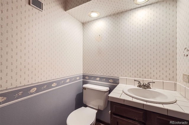 2556 S Eagle Cir, Aurora, CO 80014 - half bath featuring wallpapered walls, toilet, and vanity