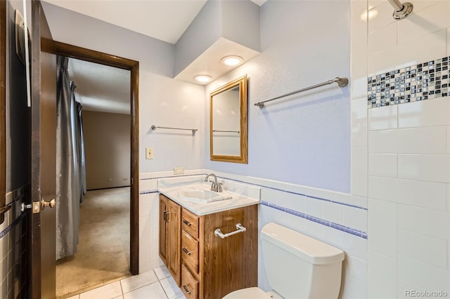 2556 S Eagle Cir, Aurora, CO 80014 - bathroom with vanity, toilet, tile patterned flooring, wainscoting, and tile walls