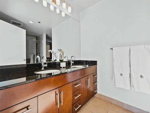 bathroom with vanity, tile patterned flooring, and a tile shower