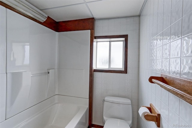 full bath with  shower combination, tile walls, and toilet