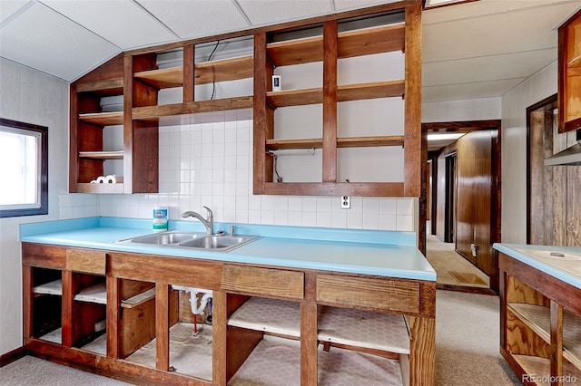 kitchen with light carpet, open shelves, a sink, and light countertops