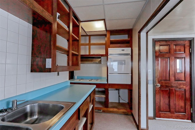 kitchen with backsplash, oven, a sink, extractor fan, and a warming drawer