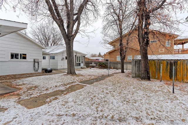 yard covered in snow with fence