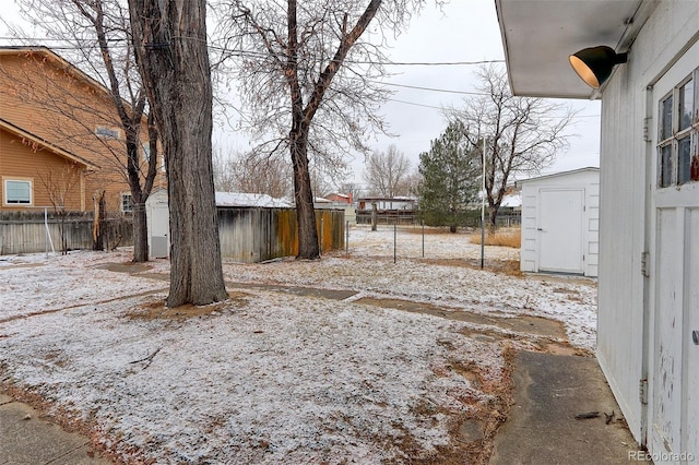 view of yard featuring a storage shed, an outdoor structure, and fence