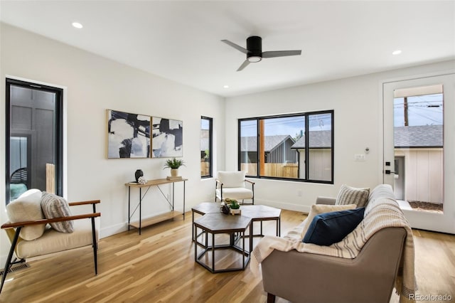 living room with a wealth of natural light, light hardwood / wood-style flooring, and ceiling fan