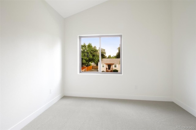 unfurnished room with vaulted ceiling and carpet floors