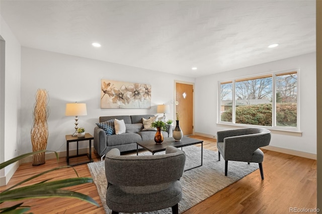 living area with recessed lighting, baseboards, and light wood finished floors