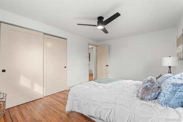 bedroom with a ceiling fan, a closet, and light wood-style flooring