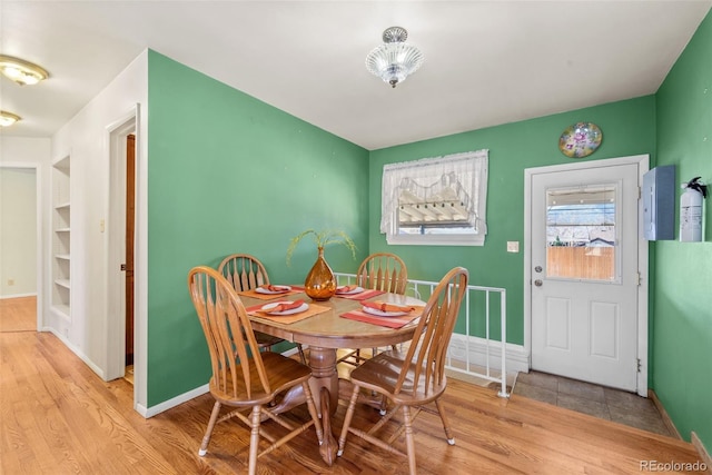 dining space with built in features and light hardwood / wood-style flooring