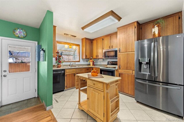 kitchen with sink, light tile patterned flooring, pendant lighting, and stainless steel appliances