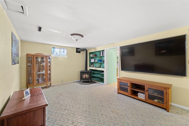 living room featuring carpet and a wood stove