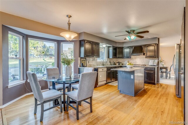 14915 Gleneagle Dr, Colorado Springs, CO 80921 - kitchen with custom exhaust hood, dark brown cabinetry, light countertops, and a kitchen island
