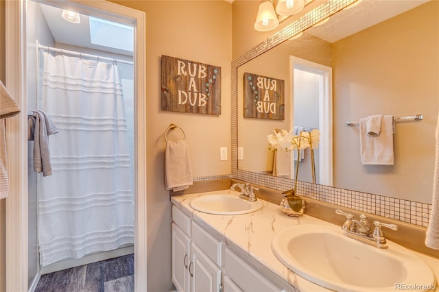14915 Gleneagle Dr, Colorado Springs, CO 80921 - full bathroom featuring double vanity, wood finished floors, a shower with curtain, and a skylight