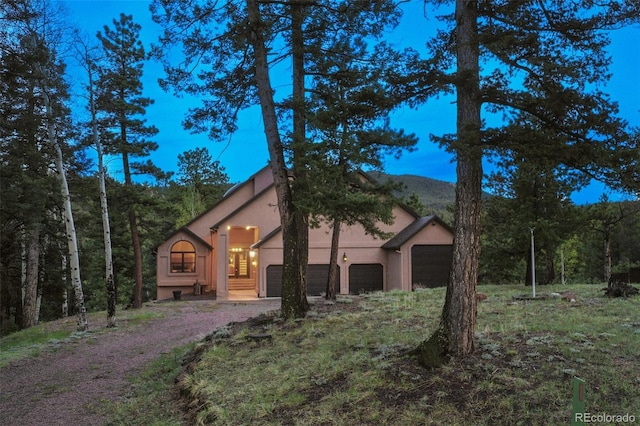 2100 Elk Rdg, Divide, CO 80814 - view of side of home with stucco siding, a garage, and dirt driveway