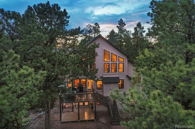2100 Elk Rdg, Divide, CO 80814 - back of house at dusk with stairway, stucco siding, and a wooden deck