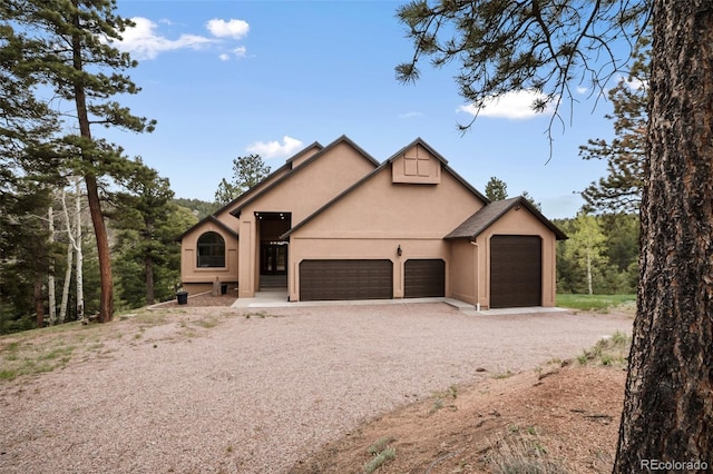 2100 Elk Rdg, Divide, CO 80814 - view of front of home with dirt driveway, stucco siding, and a garage