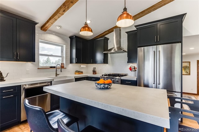 47 Wykagyl Cir, Westcliffe, CO 81252 - kitchen with a kitchen bar, a sink, dark cabinets, stainless steel appliances, and wall chimney exhaust hood