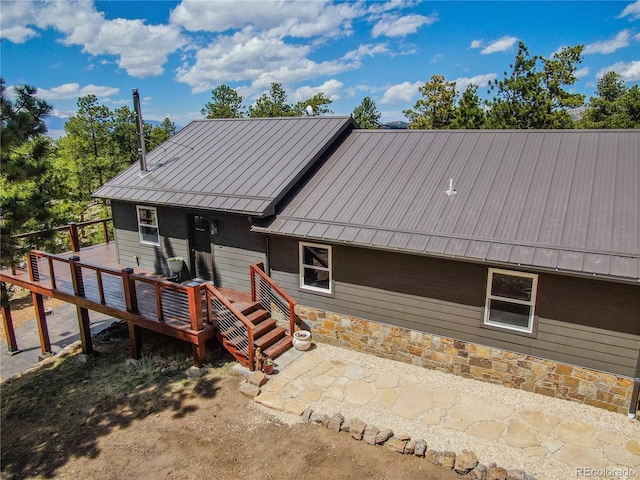 47 Wykagyl Cir, Westcliffe, CO 81252 - rear view of house with stone siding, a standing seam roof, a deck, and metal roof