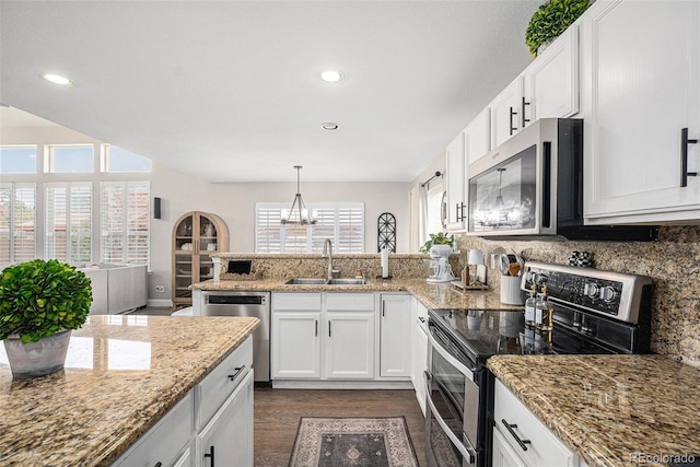 13340 Saint Paul St, Thornton, CO 80241 - kitchen featuring stainless steel appliances, a peninsula, dark wood-style floors, white cabinets, and decorative backsplash