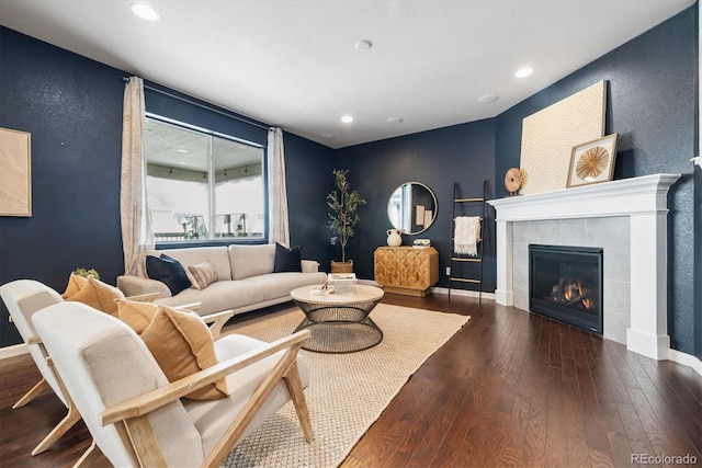 living room with baseboards, a tiled fireplace, hardwood / wood-style flooring, and recessed lighting