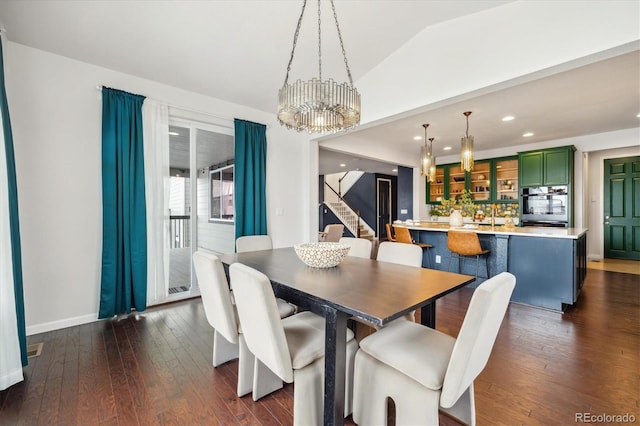 dining space with dark wood-style floors, stairs, vaulted ceiling, a chandelier, and recessed lighting