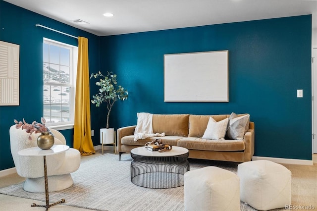 living room featuring plenty of natural light, carpet flooring, visible vents, and baseboards