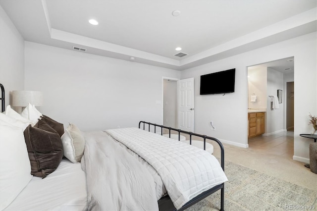 bedroom featuring baseboards, a tray ceiling, visible vents, and light colored carpet